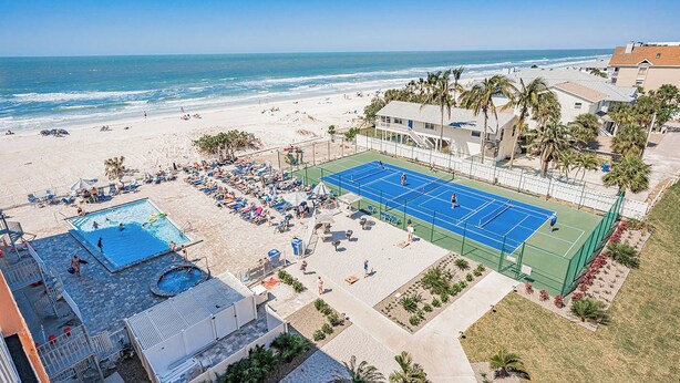 A beachfront property with a tennis court, swimming pool, and beach access. - Gulf Coast Bliss Awaits - Reef Club 505 (Indian Rocks Beach)