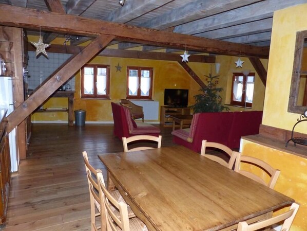 Un comedor rústico con mobiliario de madera y un techo alto con vigas a la vista.