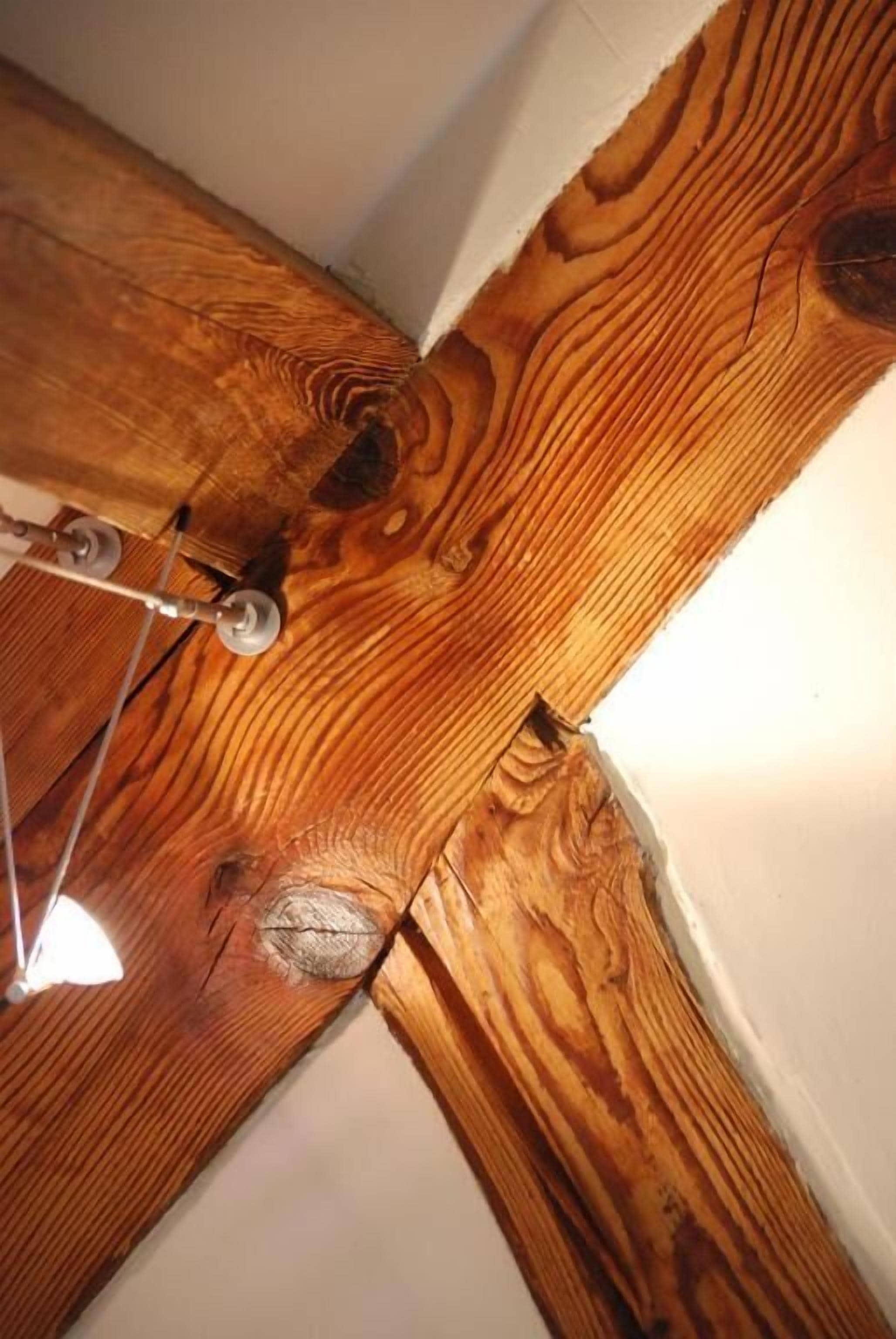 Eine Holzbalkenkonstruktion mit sichtbaren Metallbeschlägen.