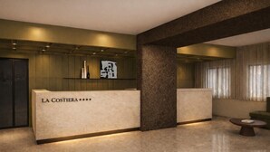 A reception area with a reception desk labeled 'LA COSTERA *****', a large pillar, and a seating area with a table and chairs. - Hotel La Costiera (Giugliano in Campania)