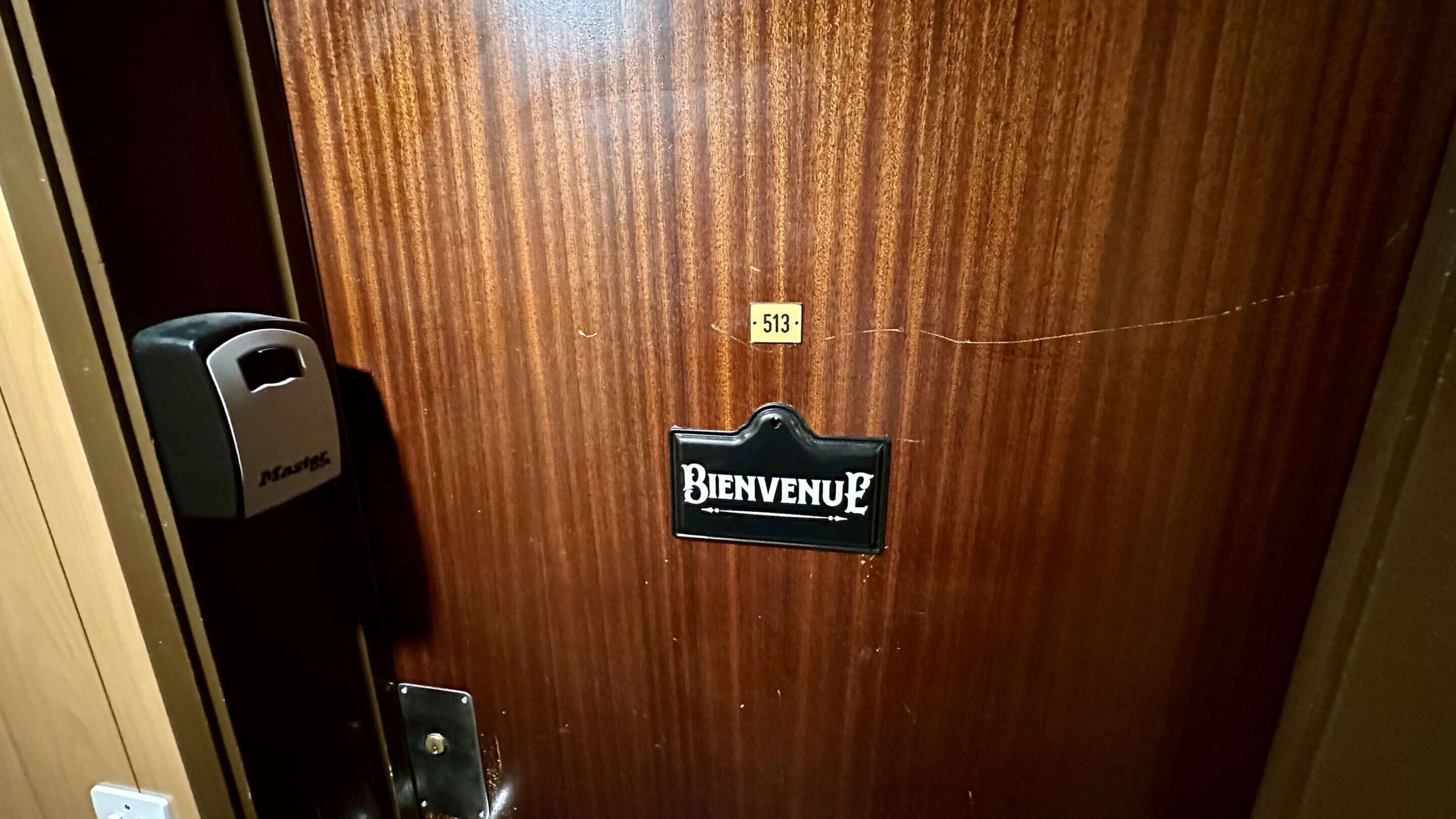 A wooden door with a "Bienvenue" sign and a room number "513".
