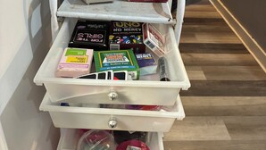 A storage cart with various board games and a BINGO set. - Soothing 2-bedroom house with AC in charming 3 mins from Dearborn Hts (Inkster)