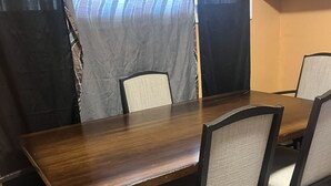 A dining table with six chairs, a dark wooden finish, and a grey upholstered seat. - Soothing 2-bedroom house with AC in charming 3 mins from Dearborn Hts (Inkster)