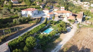 An aerial view of a residential area with multiple houses, a swimming pool, and a road. - Family Retreat at a Country House (Penafiel)
