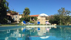 A clear swimming pool with blue lounge chairs and a white umbrella. - Family Retreat at a Country House (Penafiel)