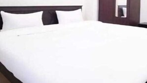 Ein Hotelzimmer mit Bett, Kleiderschrank und Spiegel.