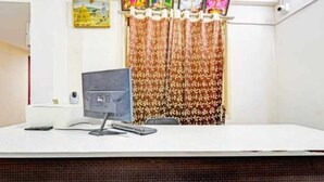 Ein Empfangsschalter mit Computer, Telefon und einem kleinen Tisch.