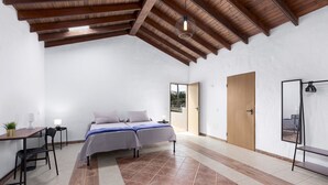 A bedroom with a bed, a desk, and a chair. - Home2Book Casa María Rustic Escape in Villaverde (Villaverde)