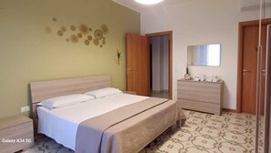 Un dormitorio con cama, cómoda, espejo y puerta.