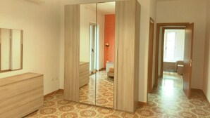 Una habitación con un espejo grande, un armario, baldosas de suelo estampadas y una lámpara.