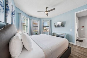 A bedroom with a bed, a ceiling fan, a TV, and a window with blinds. - Sleeps 22•Pvt pool•Theater•Game room (Kissimmee)