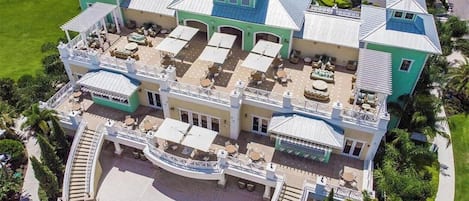 A large, multi-story building with outdoor seating areas and a pool.