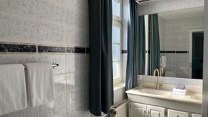 A bathroom with a white sink, a mirror, and a towel rack. - Rein Klassik Hotel (Bad Pyrmont)