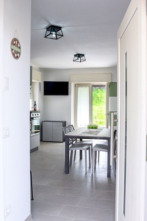 Eine moderne Küche mit Essbereich, Flachbildfernseher und Deckenventilator.