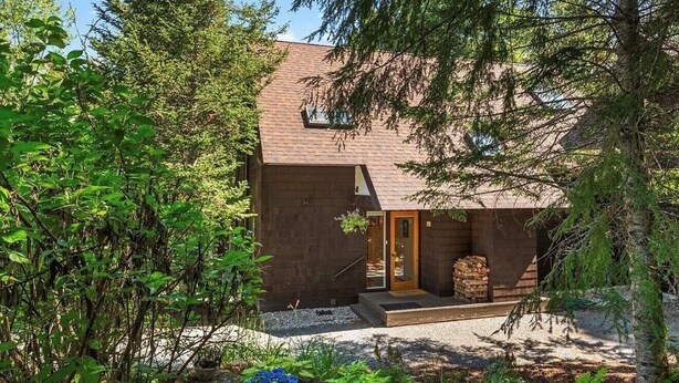 Una casa moderna con facciata in mattoni, una porta in legno e un piccolo portico.
