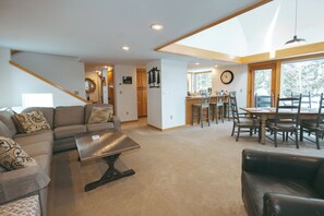 A spacious living area with a sofa, a coffee table, and a dining table with chairs. - Spacious 4BR 4Bath Home w/Front Door Shuttle to Stratton Mountain (Winhall)