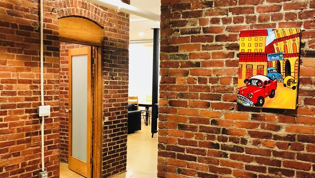 A hallway with brick walls and a polished floor, leading to a door. - Enjoyable 2-bedroom lower level apartment in charming Lynn (Lynn)