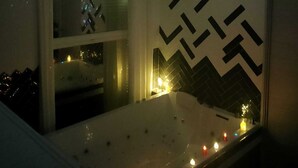Een slaapkamer met een bed, een projectie van een nachthemel op het plafond en een muur met een geometrisch patroon.