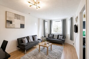 A modern living room with two sofas, a coffee table, and a painting on the wall. - Parking|Sleeps 8| 3 Bedroom House| City Centre (Edinburgh)