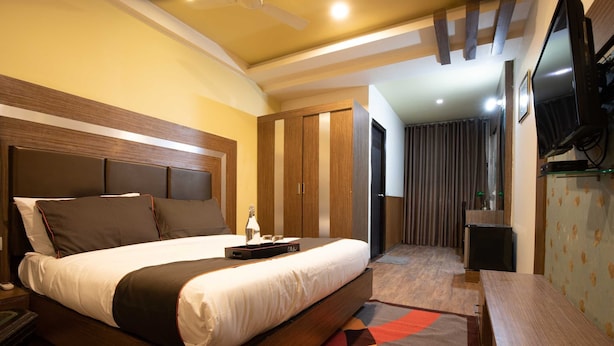 A hotel room with a large bed, a desk, a television, and a wardrobe. - Collection O Thrissur Zoo & Museum (Thrissur)