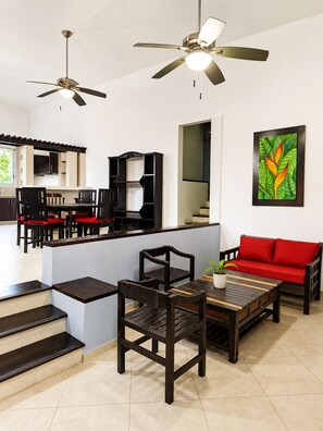 A modern living space with a dining area, a sofa, and a ceiling fan. - Casa Papalo (Palenque)