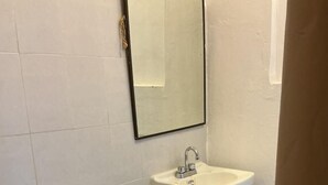 Un baño con inodoro, lavabo y espejo.