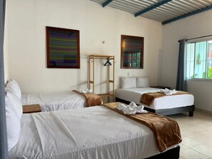 A hotel room with two beds, a wooden ladder, and artwork on the walls. - Casa Papalo (Palenque)