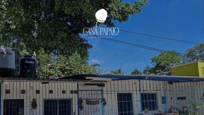 Un edificio con fachada blanca y detalles azules, y un letrero que dice "CASA PAPALO".