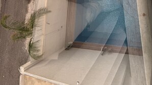 Ein Luftbild eines Grundstücks mit Swimmingpool, überdachter Terrasse und einem in der Nähe geparkten Auto.