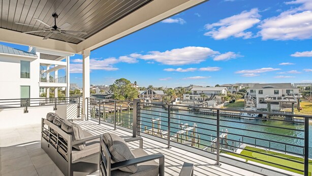 A balcony with a view of a river and buildings. - Isle Be Back|Private Pool|Waterfront|Golf Cart (Destin)