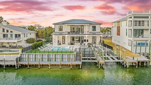 A waterfront property with a pool, dock, and multiple buildings. - Isle Be Back|Private Pool|Waterfront|Golf Cart (Destin)