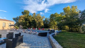 Ein Innenhof mit Swimmingpool, Gartenmöbeln und einem Gebäude mit Ziegeldach.