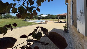 Ein Poolbereich mit Liegestühlen, einer Pergola und Blick auf die umliegende Landschaft.
