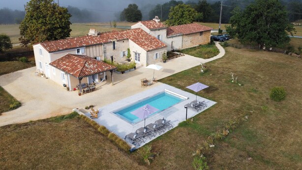 Ein Wohnhaus mit Pool, überdachter Terrasse und Garten.