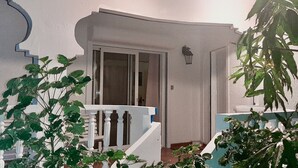 Ein weißes Gebäude mit einem weißen Balkon und einer Tür zu einem Innenraum.