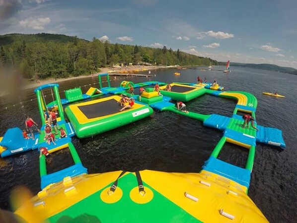 Un parque acuático inflable con diversas estructuras de juego y trampolines sobre una masa de agua.