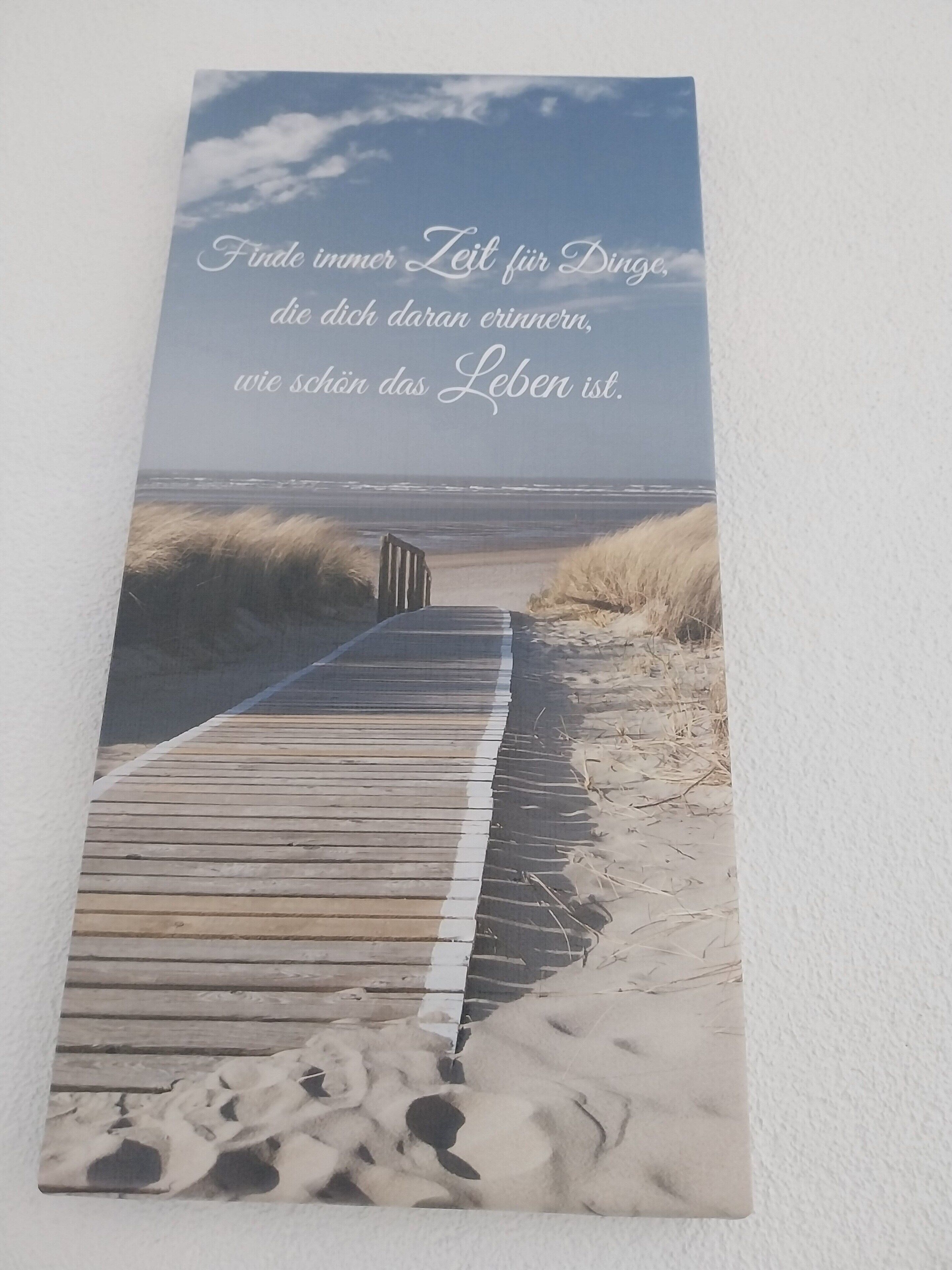 Une promenade en bois qui mène à une plage de sable bordée de dunes.