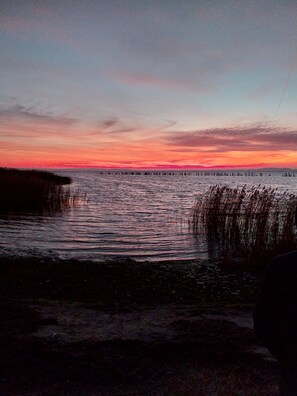 A sunset over a body of water with a pier extending into the water. - Small and quiet vacation apartment Helga (Glowe)