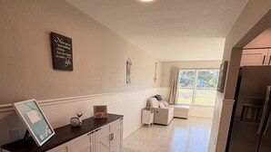 A spacious kitchen with a dark countertop, white cabinets, and a view to the living area. - "Cozy 2-bed, 1-bath retreat in peaceful Charlotte Park, Punta Gorda! (Punta Gorda)