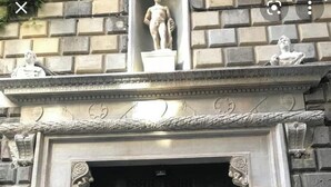 A black ornate door with intricate metalwork and a statue above it. - Palazzo Carafa Santangelo - historic residence of the 400'in the heart of the ancient city (Napoli)