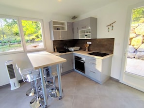 A modern kitchen with a window, built-in cabinets, a countertop, and a dishwasher.