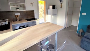 Una cocina moderna con encimera de madera, electrodomésticos integrados y una pared de acento de piedra.