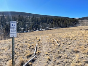 A hiking trail sign with a no motor vehicle symbol, indicating an open space outlot.