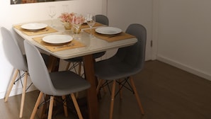 A dining area with a white table, four grey chairs, and a large mirror above the table. - Top 10 - Gleba Palhano (most prestigious neighborhood in Lda), Air, spotless, comfortable and beautiful. (Londrina)