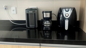 A kitchen with a coffee maker, a toaster, and a microwave on a black countertop. - Top 10 - Gleba Palhano (most prestigious neighborhood in Lda), Air, spotless, comfortable and beautiful. (Londrina)
