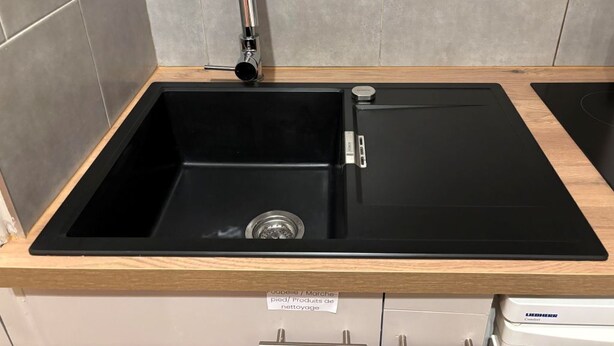 A kitchen with a black sink, a faucet, and a wooden countertop. - Le petit Toulousaing - Capitole apartment (Toulouse)