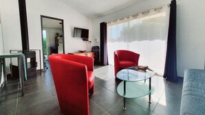 Uma sala de estar moderna com lareira, uma TV de tela plana e uma mesa de centro de vidro.