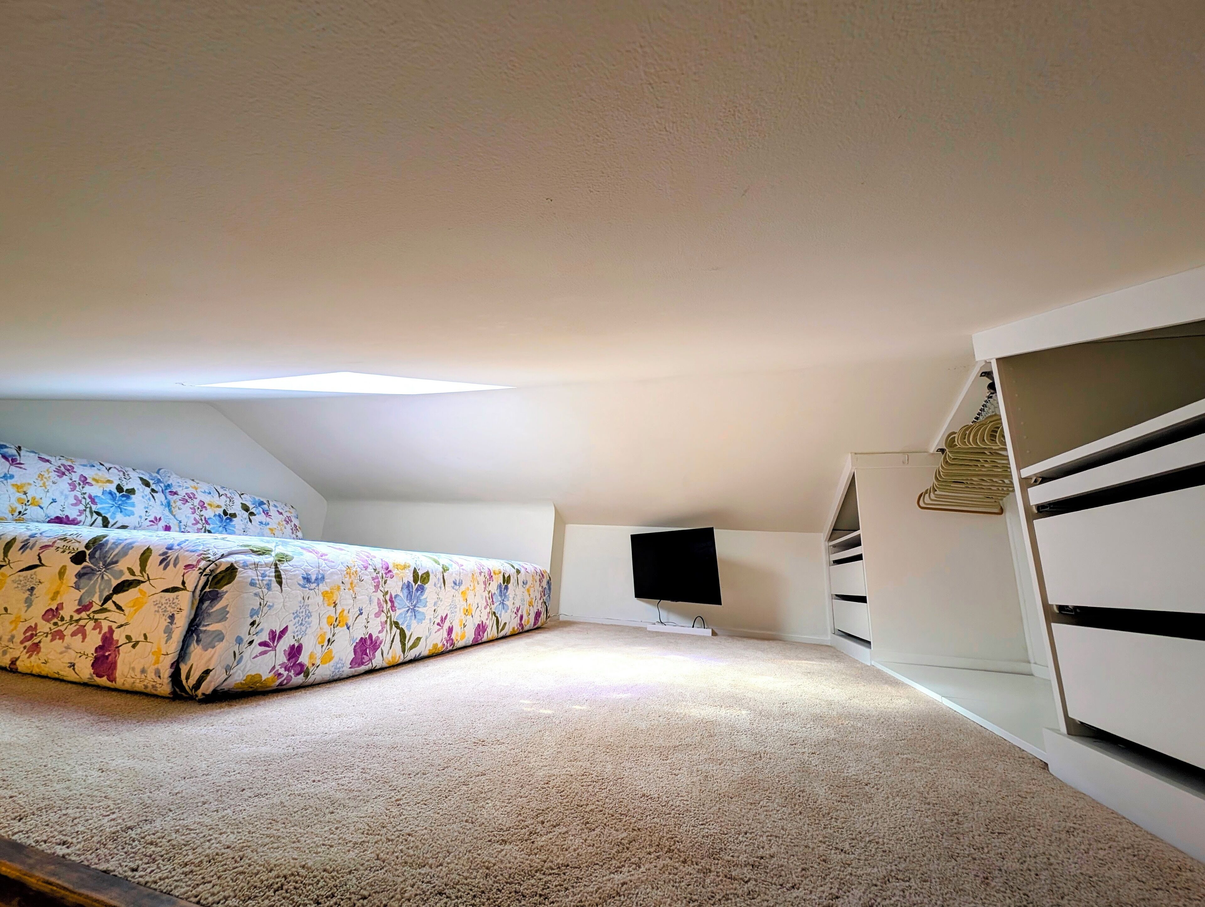 A bedroom with a bed, a TV, and a wardrobe.