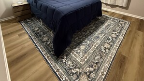 A bedroom with a bed, a nightstand, a lamp, a ceiling fan, and a patterned rug. - Ann's Adobe - 2 Bdrm Apartment in Mansfield, OH - close to Lexington & Ontario (Mansfield)
