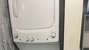 Een was- en droogcombinatie in witte kleurstelling met bedieningsknoppen en een startknop.